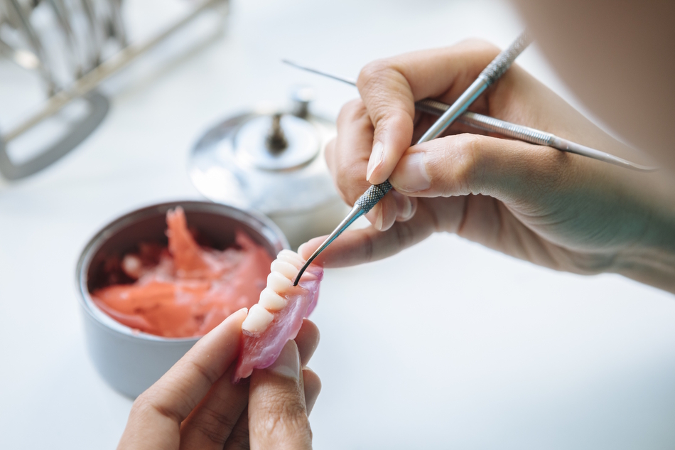 Closeup shot of hands working on a denture 2023 11 27 05 03 16 utc